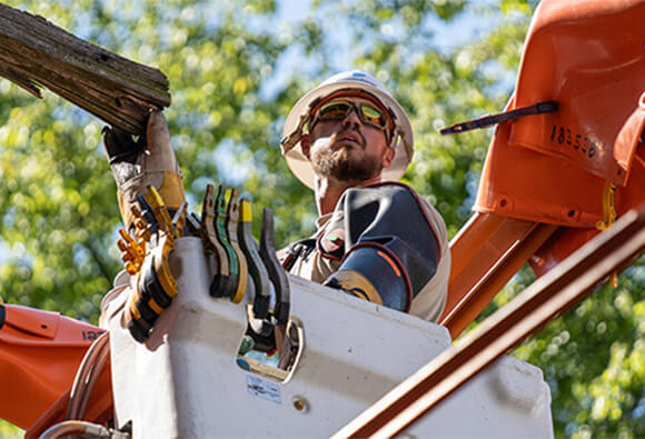 Line Worker Examining Power Line