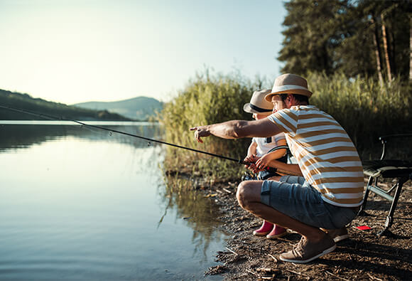 Father and Son Fishing on Lake in Mountains