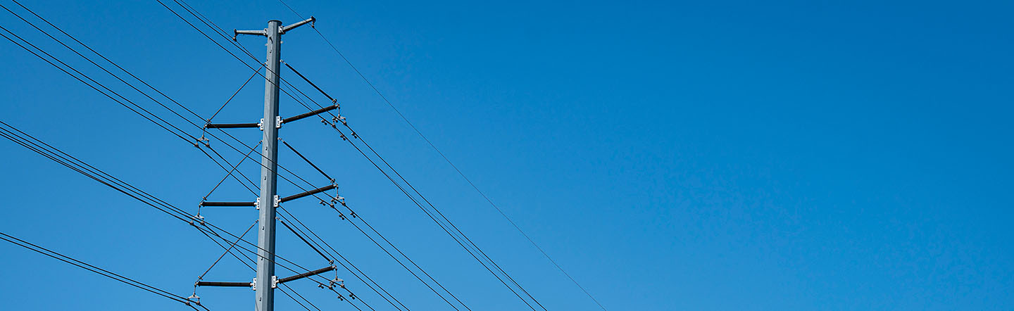 Power line poles against a blue sky