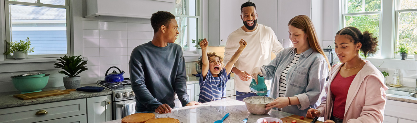 People in kitchen with excited child.