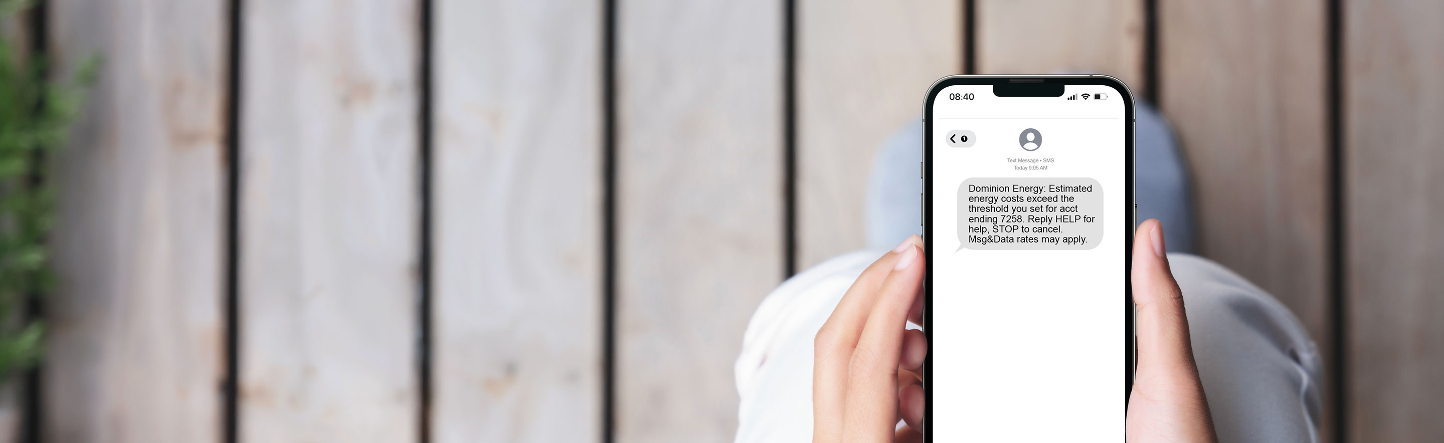 Person holding mobile device with energy usage alerts showing