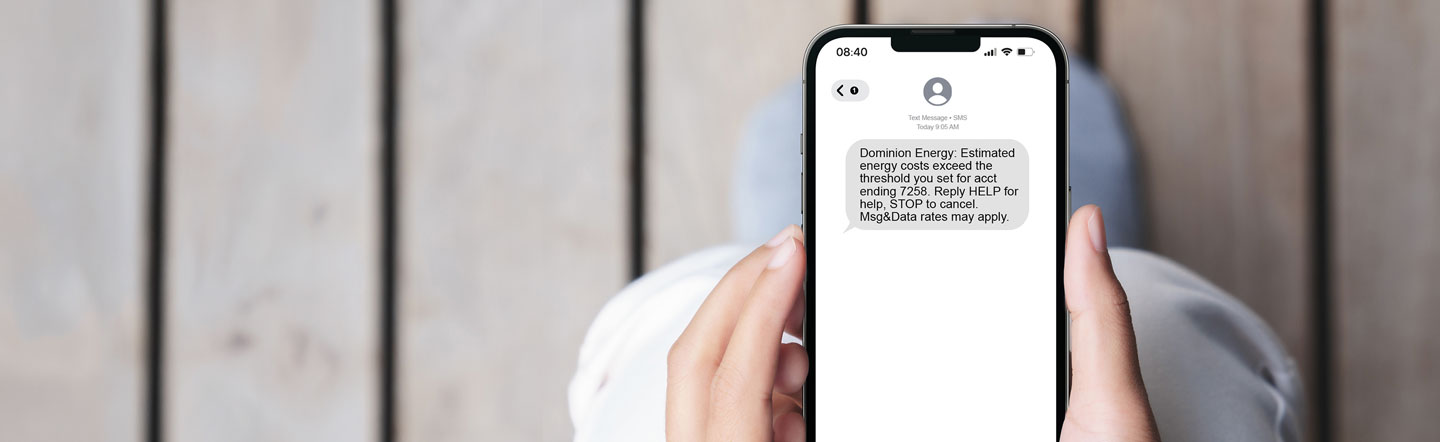 Person holding mobile device with energy usage alerts showing