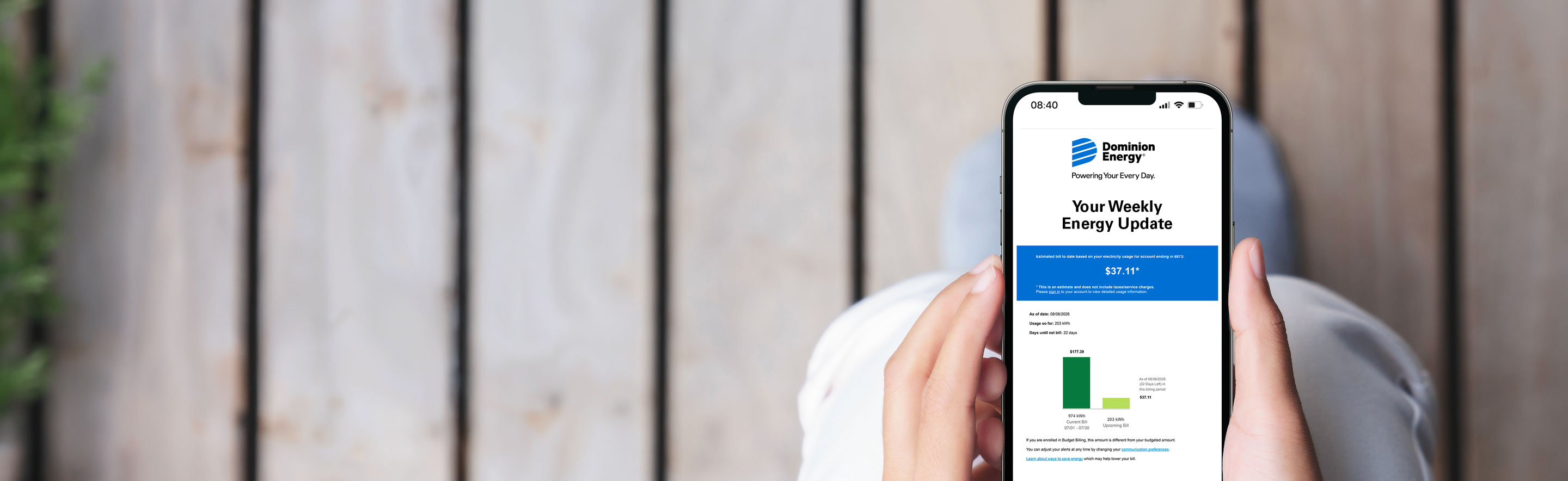 Person holding mobile device with weekly energy usage update showing
