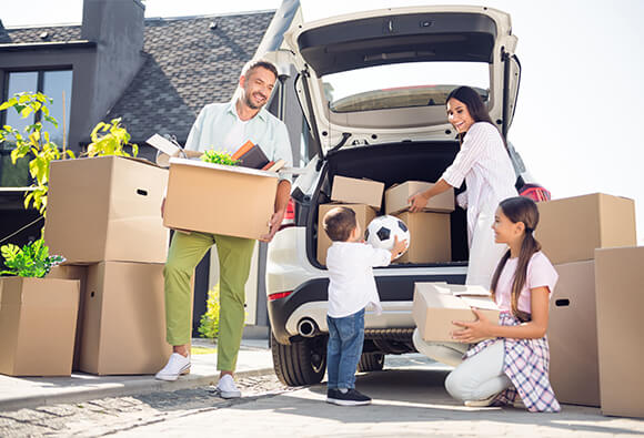 Family Loading Moving Boxes in Cars