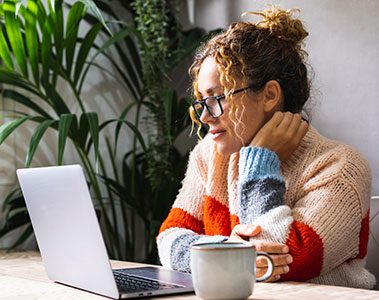 Woman at computer with cup of coffee
