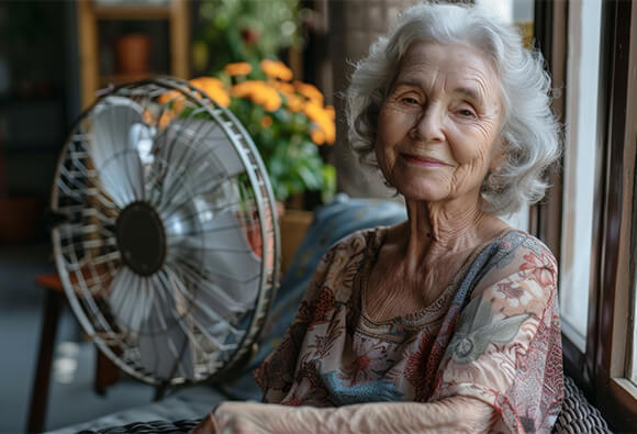 Elderly Lady Sitting Next To Fan