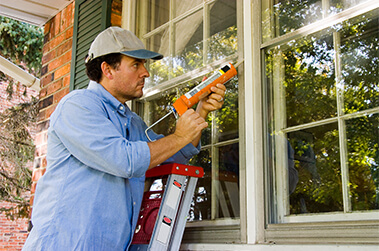Man Caulking Window Seals
