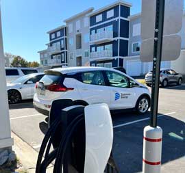electric vehicle parked near charger in front of Keystone Luxury Apartments