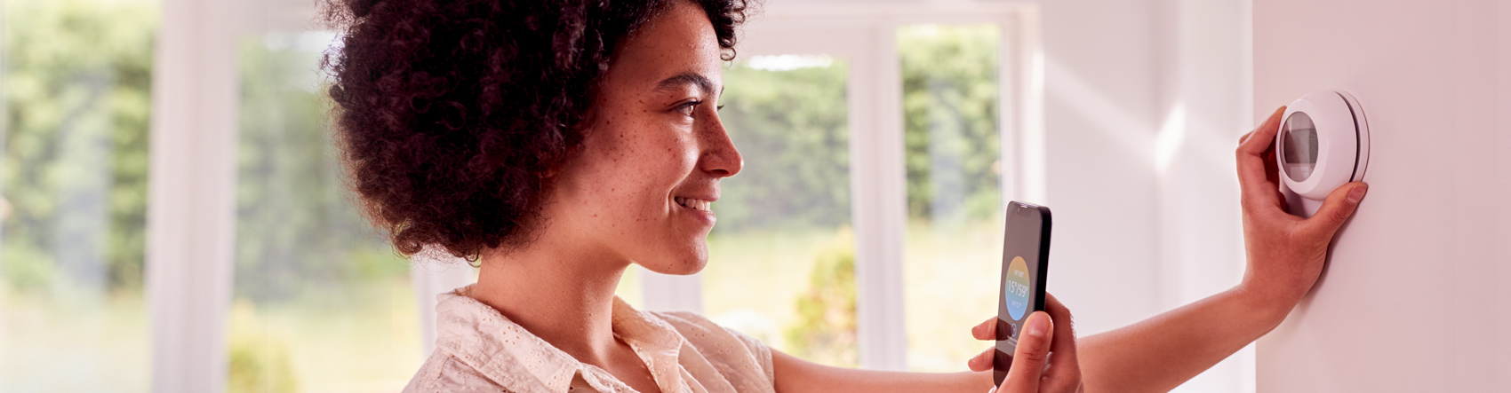 women adjusting thermostat