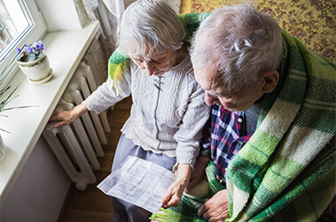 Elderly Couple Walking Out Front Door of House