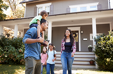 Family in Front Yard of House